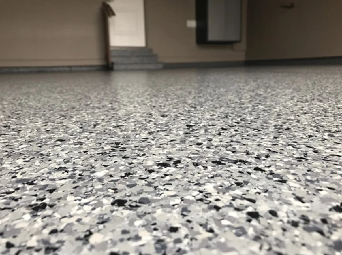 Decorative flake epoxy garage floor — multi-color vinyl chip broadcast, close up